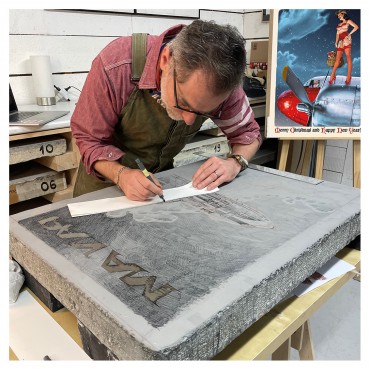 Romain Hugault dessinant sa pierre à l'atelier.